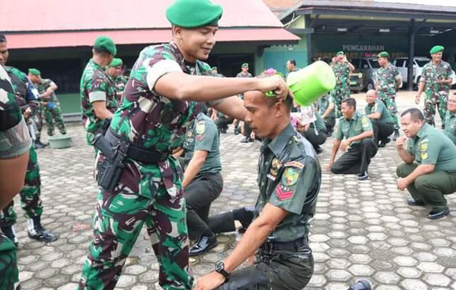 Dandim 0416 Bungo Tebo melakukan siraman terhadap prajurit yang naik pangkat.