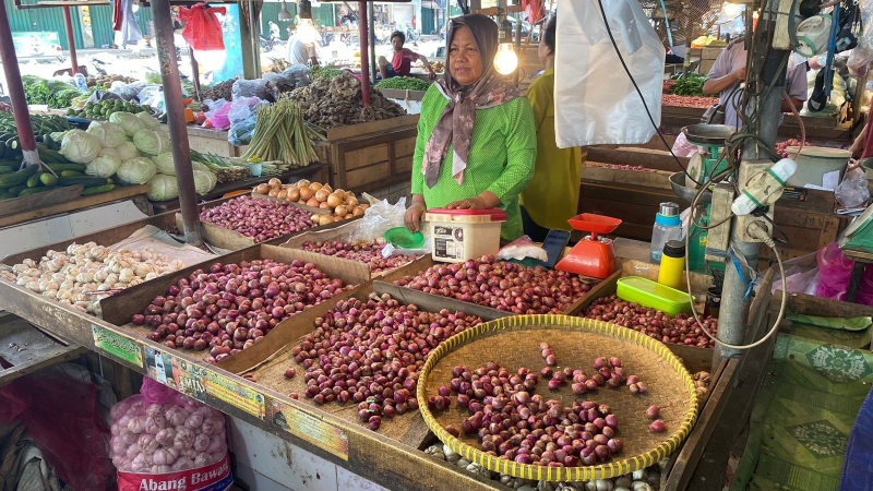 Pedagang bawang di pasar Angso Duo tengah menunggu pembeli. Kini harga naik drastis menjadi Rp38 ribu hingga Rp40 ribu.